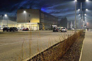 Budynek nocą oświetlony lampami i lekka mgła. © W Korczewski