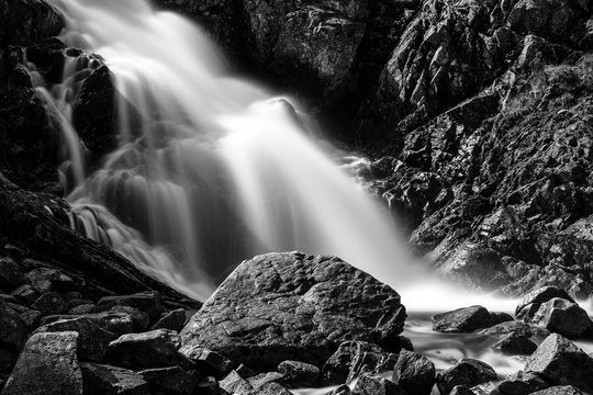 waterfall in the mountains in black and white