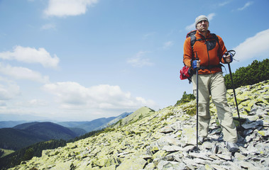 Summer hike in the mountains with a backpack and tent.
