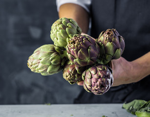 Obraz premium Chefkoch in der Küche mit Frischem Gemüse(Artischocken)