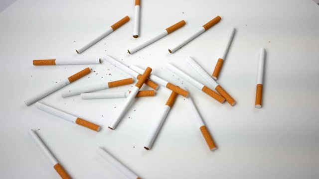 Spinning generic cigarettes spinning over white - Overhead View
