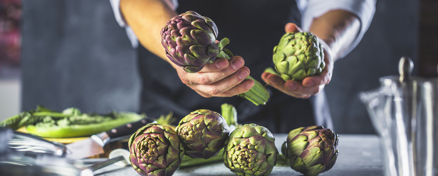 Chefkoch in der K&uuml;che mit Frischem Gem&uuml;se(Artischocken)