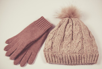Wool hat and gloves for winter weather on a white background.