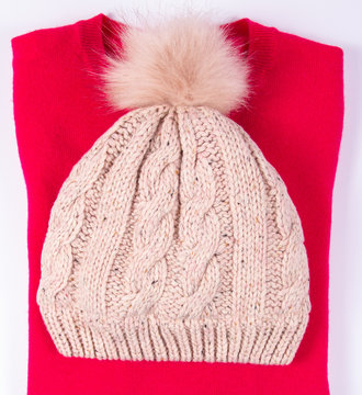Wool hat and sweater for winter weather on a white background.