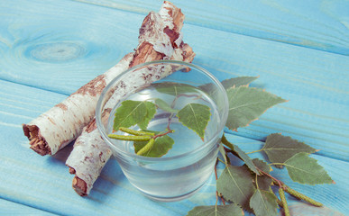 A glass of birch juice on wooden background