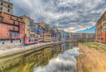 Fototapeta na wymiar Colorfull river-front houses lining the Onyar river, mostly built on top of old medieval defense walls, Girona, Catalonia, Spain