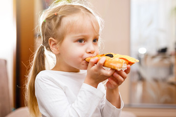 Little girl eating pizza