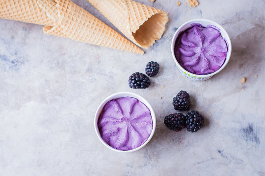 Delicious berry blackberry purple ice cream on gray stone table background. Summer tasty dessert. Copy space, top view