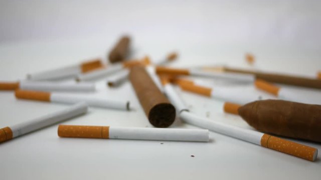 Spinning generic cigarettes and cigars spinning over white 