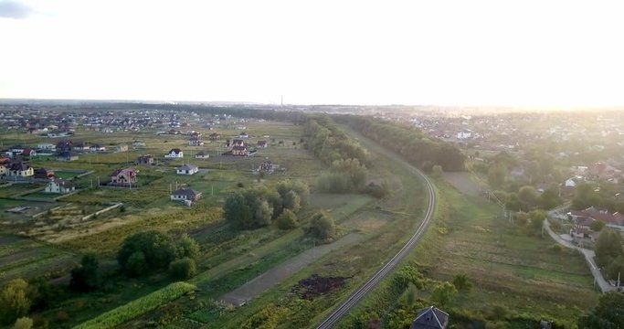 Empty railway. Endless railway without train in sunset. Empty winding railway. Autumn sunset. Beautiful sky. Aerial shot. railway through the village without a train.