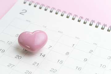 Fototapeta na wymiar Calendar with pink heart shape on 14 February on pink background using as romantic Valentines day concept