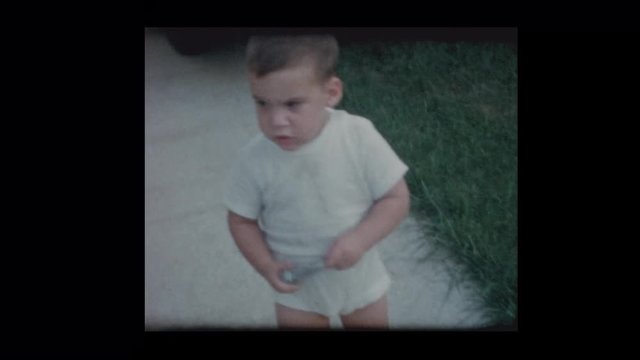 1961 Cute little boy in underwear with antique car in driveway