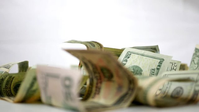 Crumpled up American cash currency money spinning over white