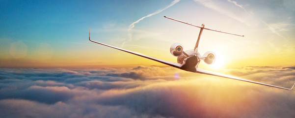 Fototapeta premium Odrzutowiec prywatny samolot latający nad chmurami w pięknym świetle słońca.