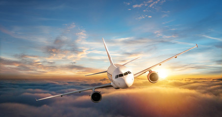 Fototapeta premium Odrzutowiec samolotu komercyjnego latające nad chmurami w pięknym świetle słońca.