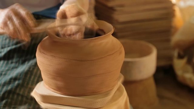 Potter at work. Close-up of woman making ceramic pot on the pottery wheel. High speed.