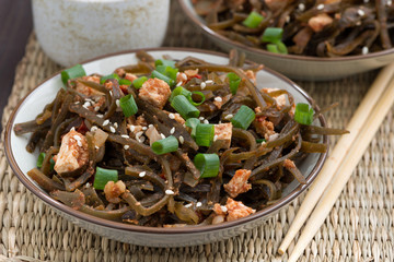 sea cabbage salad with tofu in bowls, closeup