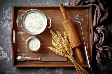 Dough with flour on an old background in a composition with kitchen accessories