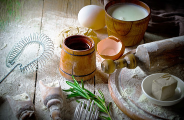 Dough with flour on an old background in a composition with kitchen accessories