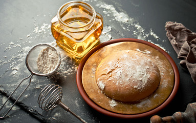 Dough with flour on an old background in a composition with kitchen accessories