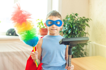 Boy child superhero costume playing is cleaning the house. Concept of children helping their parents