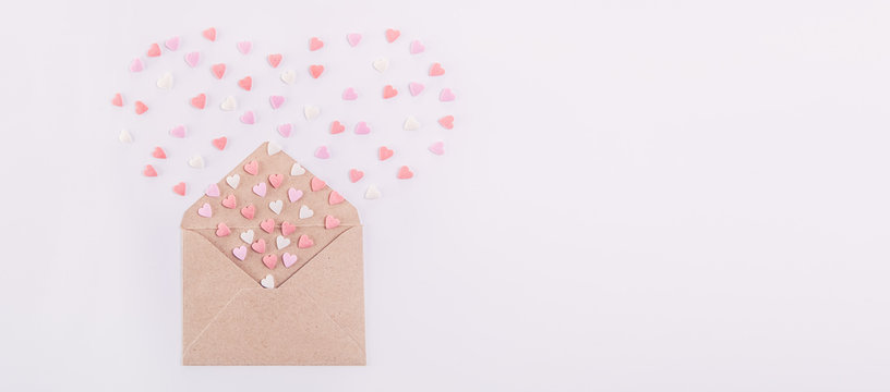 Sweets Sugar Candy Hearts Fly Out In The Form Of Heart From Craft Paper Envelope On The White Background . Valentine Day Concept. Gift For Lover. Selective Focus. Space For Text. Wide Banner