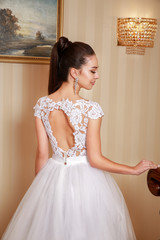 Fototapeta premium Beautiful wedding dress. Bride in wedding dress in a luxury apartment.