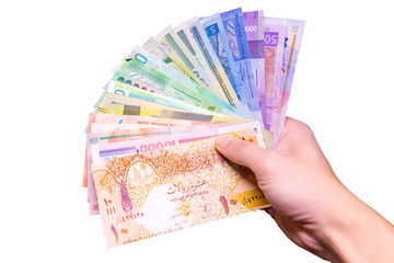 Different various money background in hand. Many cash banknotes isolated on white background