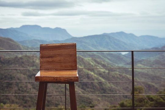 Wooden single chair on the balcony with view of peaceful mountain