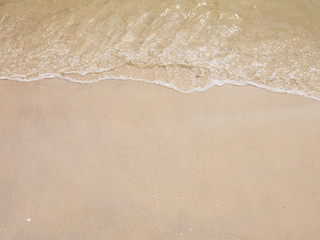 Wide angle view of smooth wet white sand with a small tide washing ashore. Hua Hin, Thailand....