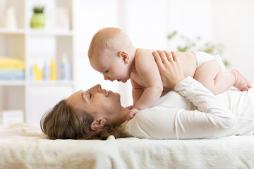 Portrait of mother and baby laughing and playing