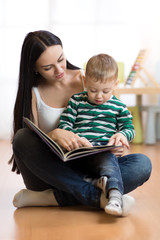 Young mother reads book to son. Cute little child boy and his mom.