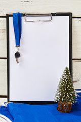 Coach's clipboard and whistle. Christmas tree miniature. Team's results of the year concept.