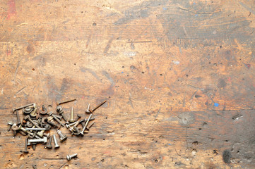 Old used dirty workbench with screws for background. - obrazy, fototapety, plakaty