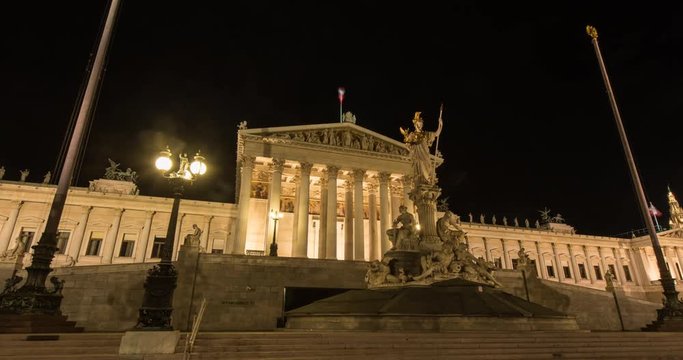 VIENNA, AUSTRIA &ndash; DECEMBER 2015 : Moving timelapse / hyperlapse of Vienna Parliament at night with statues in foreground
