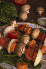 Meat on a skewer rests on a wooden table