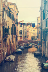 vertical cityscape of venice, vintage street view of water canal with boats and traditional bridge