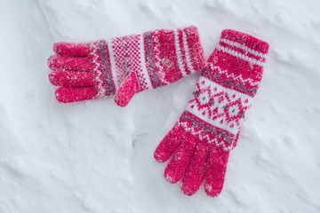 Snow covered gloves on snow. A Winter background