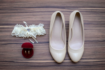 Wedding shoes, Bridal garter and wedding ring in a box on wooden background