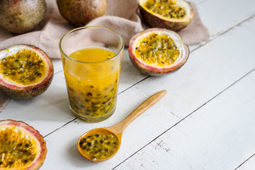 Passion fruit and juice on white wooden background