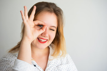 Positive successful woman looking through fingers