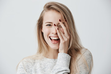 Headshot of cute woman with dark eyes, blonde long hair, happy gentle smile rejoicing her success. Cheerful woman having birthday having pleased expression and pleasure. Face expressions - obrazy, fototapety, plakaty