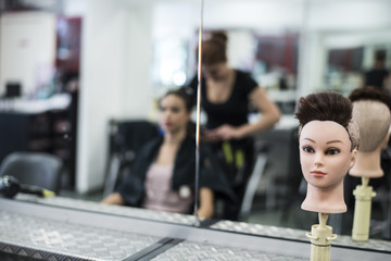 Hairdresser cuts and comb young womans hair