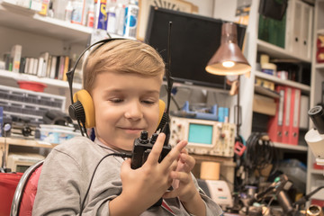Little boy with headphones using walkie talkie.