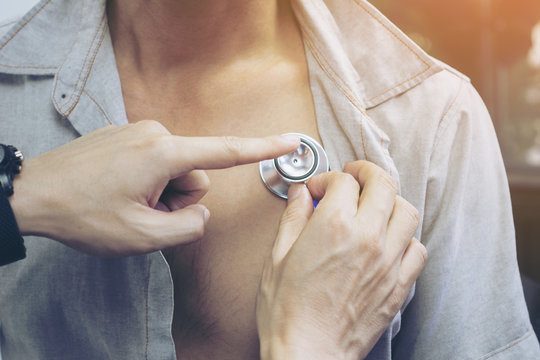 Closeup Of Hand Doctor With Stethoscope On The Chest Of Young Men