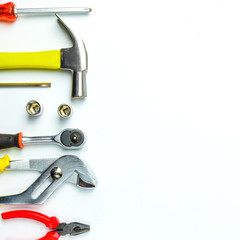 Top view of Working tools,wrench,socket wrench,hammer,screwdriver,plier,electric drill,tape measure,machinist square and safety glasses on white background.flat lay design for construction concept