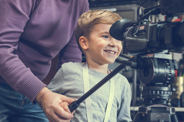 Happy boy learning how to become camera operator.