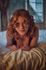 Playful redheaded woman in sexy dress and leather harness