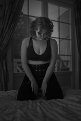 Playful redheaded woman in sexy dress and leather harness