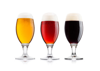Cold glasses of lager stout and red beer with dew